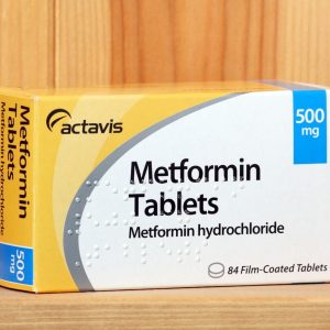 Bracknell, England - January 14, 2014: A box of Metformin tablets produced by the pharmaceutical company Actavis, on a wooden shelf. Metformin is an oral treatment for type 2 Diabetes.